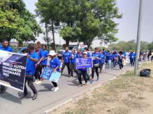 A photo of people marching with banners commemorating the World Autism Awareness Day