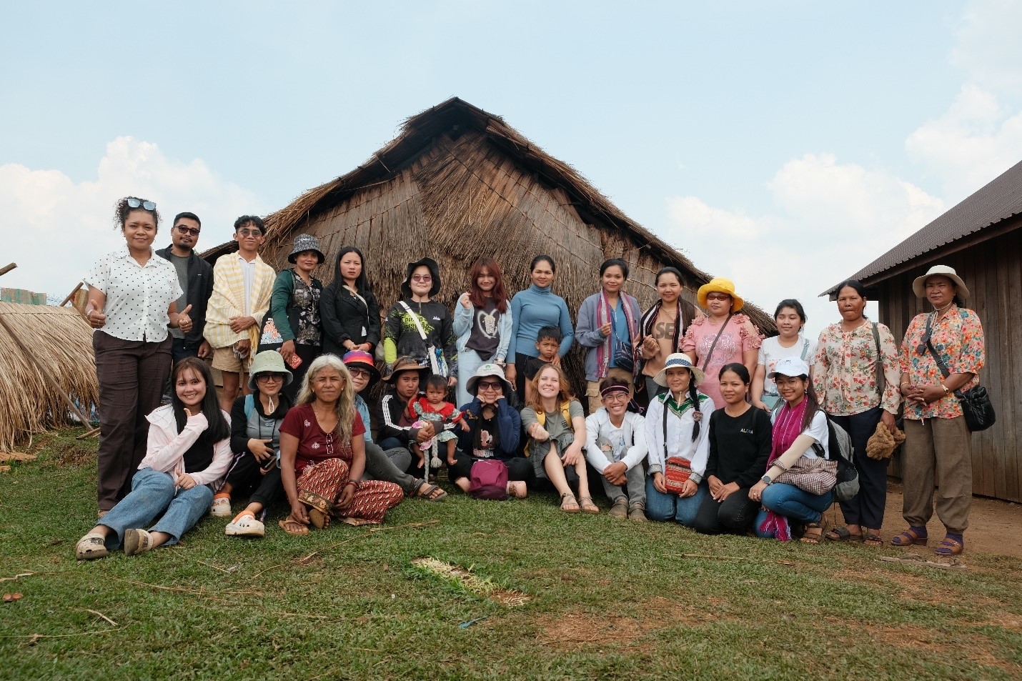 A group photo of the trip participants posing in front of a hut.
