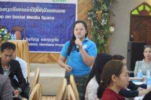 A photo of a woman speaking in front of people, sharing her thoughts on the digital civic space in Laos 