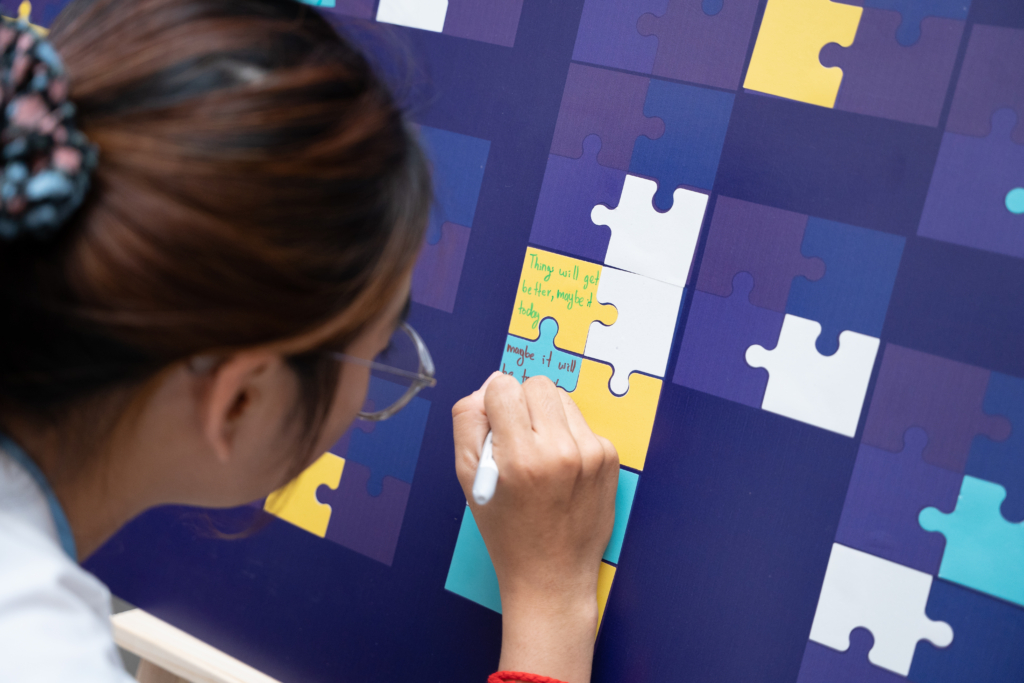 A puzzle stand where participants select a piece of the puzzle and write their messages 